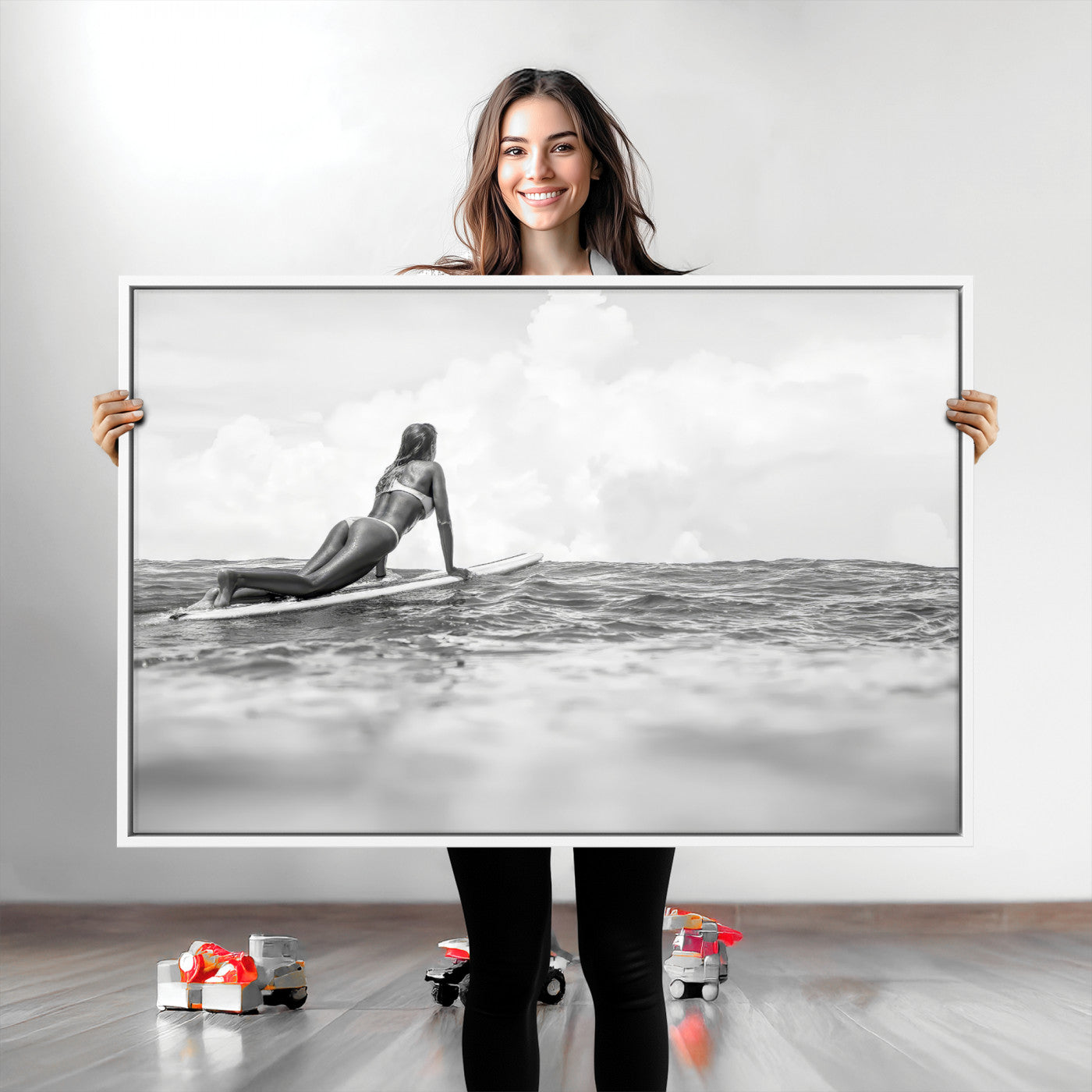 A black and white ocean scene featuring a surfer girl waiting on her board, gazing at the horizon, capturing a tranquil and adventurous coastal moment.