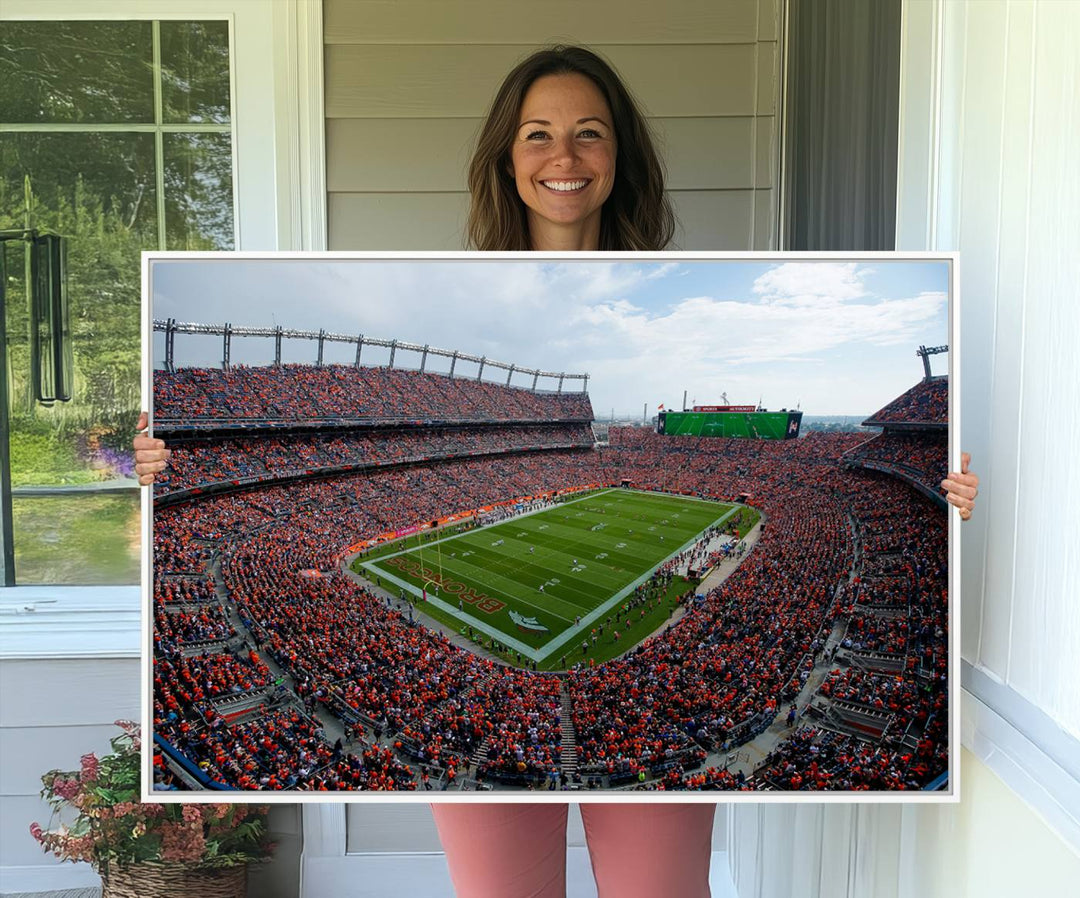 The Denver Broncos Football Print features a vibrant, fan-filled orange stadium overlooking the football field.