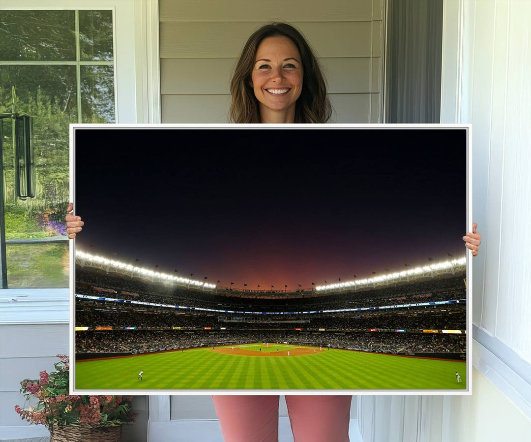 A night game at Yankee Stadium depicted on canvas beneath a sunset sky.