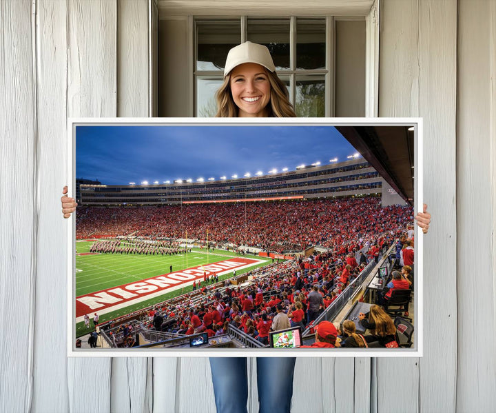 A vibrant wall art captures the essence of Madison Camp Randall Stadium, depicting a sea of fans in red and white during a Wisconsin Badgers football game under bright lights.