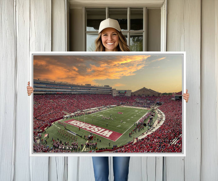 The wall features a Wisconsin Badgers wall art canvas print, capturing the vibrant atmosphere of a full Camp Randall Stadium at sunset.