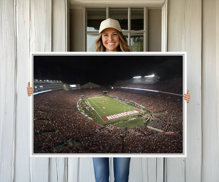 A painting of a stadium packed for a Wisconsin Badgers game, with WISCONSIN clearly visible in the end zone at Camp Randall Stadium.