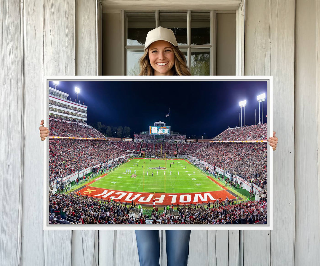 The wall art titled Wolfpack Football Team Print features Raleigh Carter-Finley Stadium at night, reproduced on premium canvas.