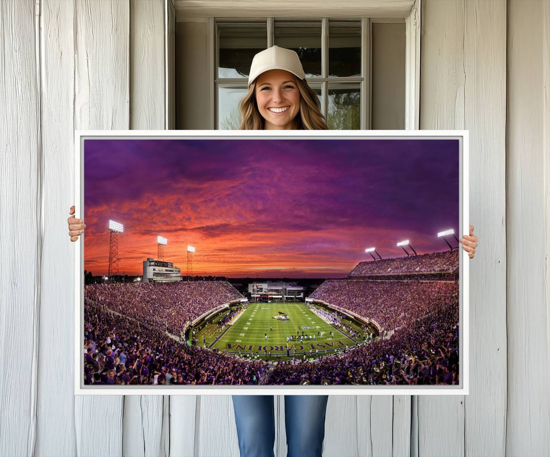 A sunset over Dowdy-Ficklen Stadium, Greenville, captured on museum quality canvas with vibrant purple and orange skies.