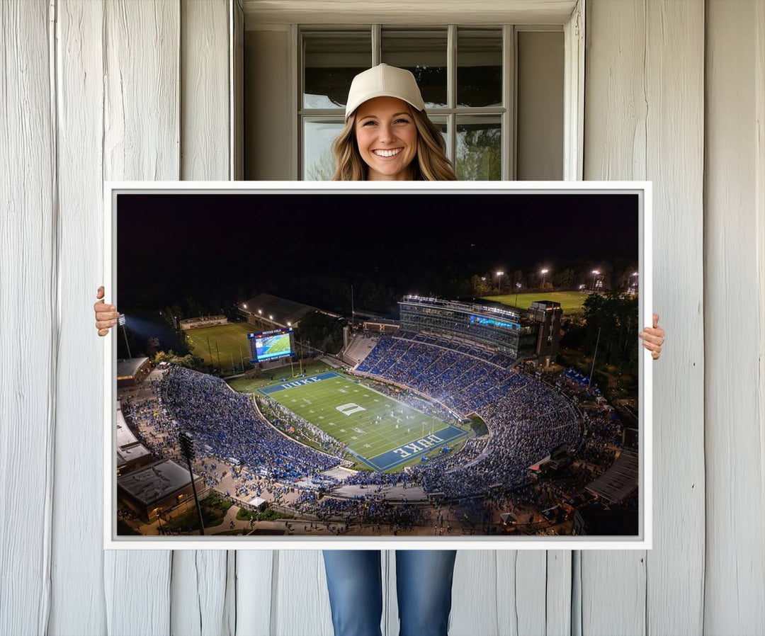 Night aerial view of packed Duke Blue Devils Wallace Wade Stadium, surrounded by trees and illuminated by lights; perfect for high-resolution prints.