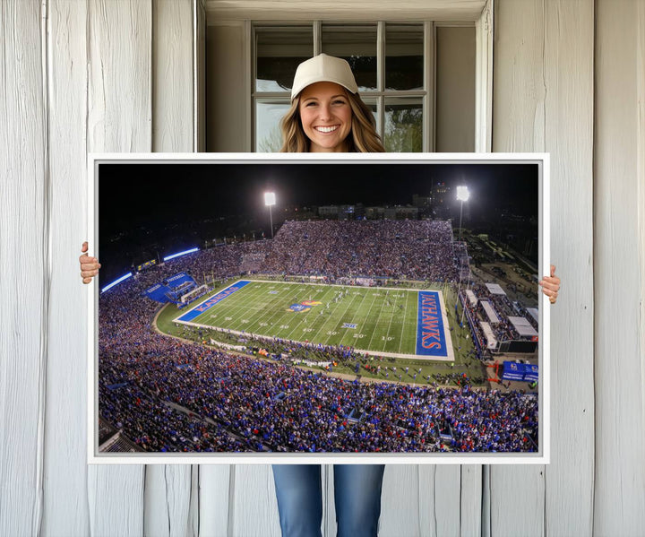 A canvas depicting an aerial view of the University of Kansas Memorial Stadium, showcasing bright lights and a lush green field at night.