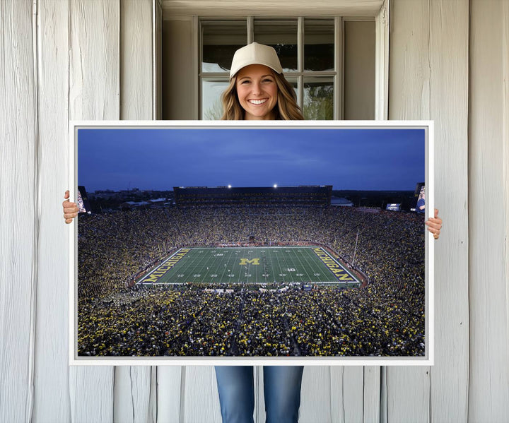 Wall art featuring an aerial shot of Michigan Stadium at dusk, showcasing the University of Michigan Wolverines M logo.