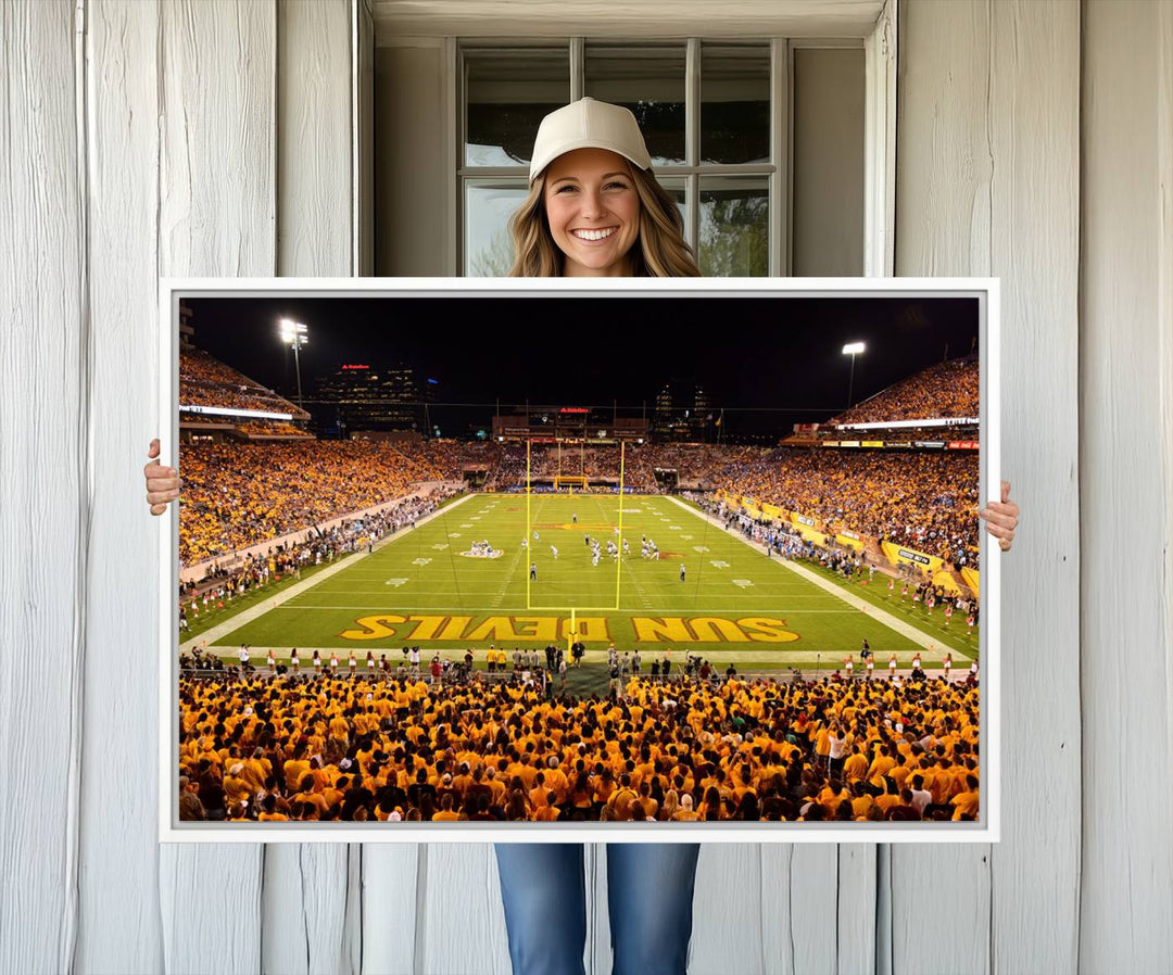 The Phoenix Stadium Canvas Wall Art features a vibrant depiction of a packed stadium filled with ASU Sun Devils fans wearing yellow shirts.