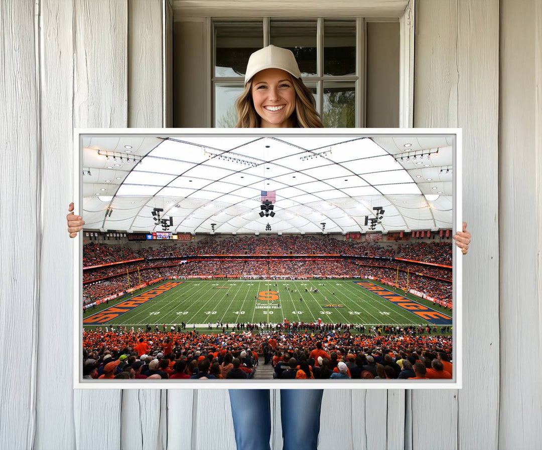 Fans fill the Syracuse JMA Wireless Dome, highlighted in orange and blue under a vaulted roof on this premium canvas print of the scene.