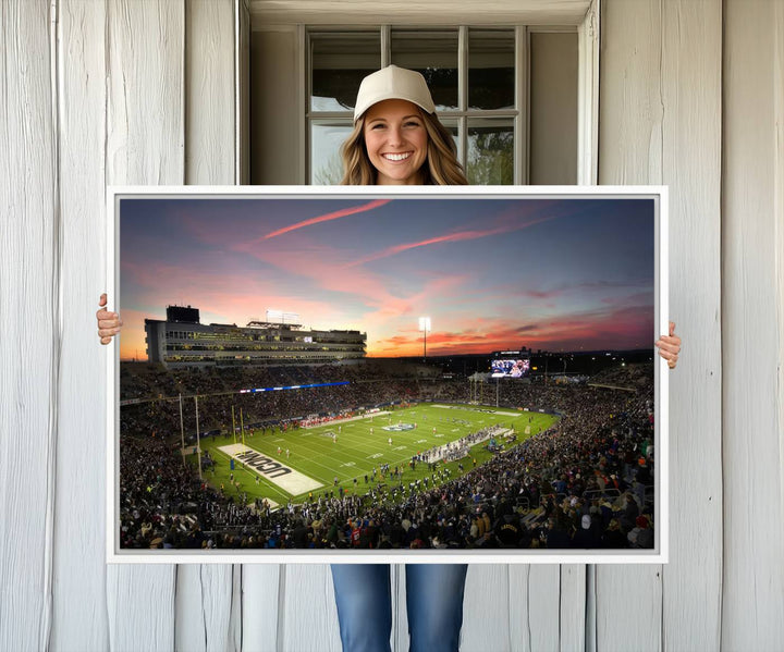 This wall art canvas print captures UCONN Huskies fans energizing a sunset scene at East Hartfords Pratt & Whitney Stadium.