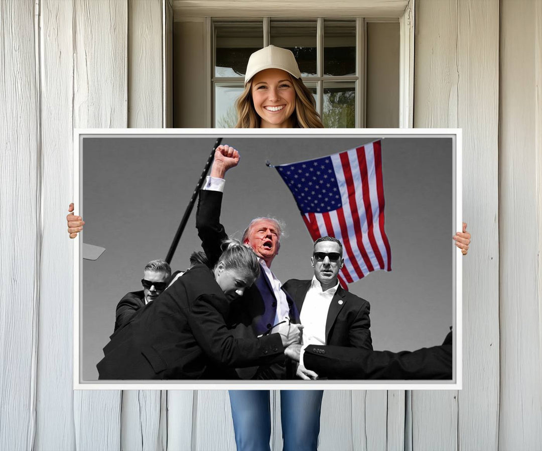 A wall art print depicts Donald Trump mid-speech, surrounded by guards and an American flag. This piece is titled Donald Trump Assassination Attempt Wall Art Print.