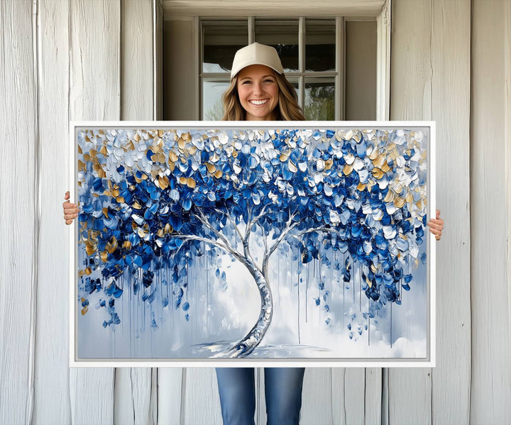 The Blue and Gold Abstract Tree Wall Art showcases a swirl trunk and features blue, silver, and gold leaves on a framed canvas print.