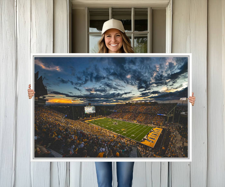 Laramies War Memorial Stadium Print captures a stunning scene of the stadium during sunset, set under a partly cloudy sky illuminated by bright lights.