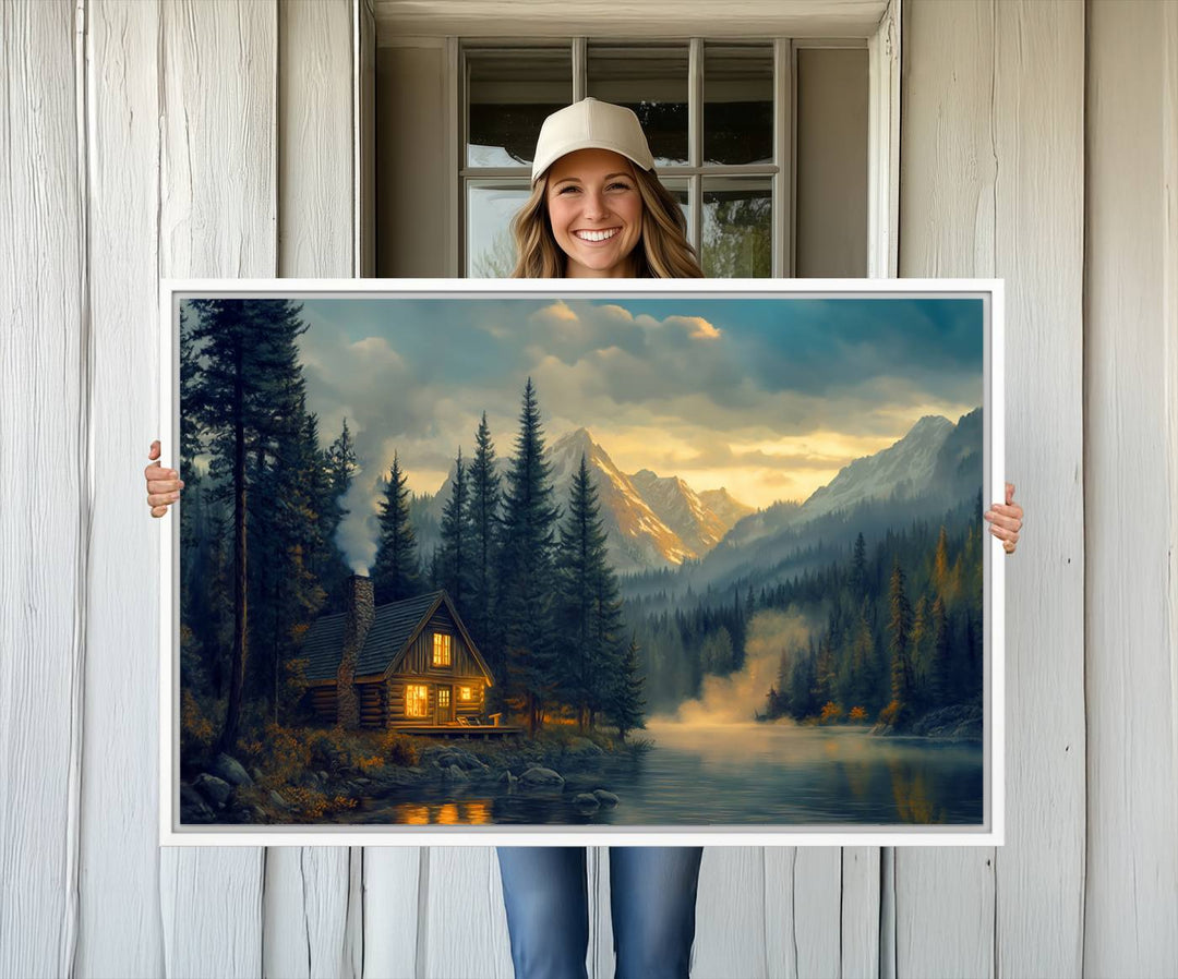 Serene sunset lake wall art: a cozy mountain cabin with lights, framed by pine trees and set against a moody sky. Ideal for adding rustic lodge charm to your space.