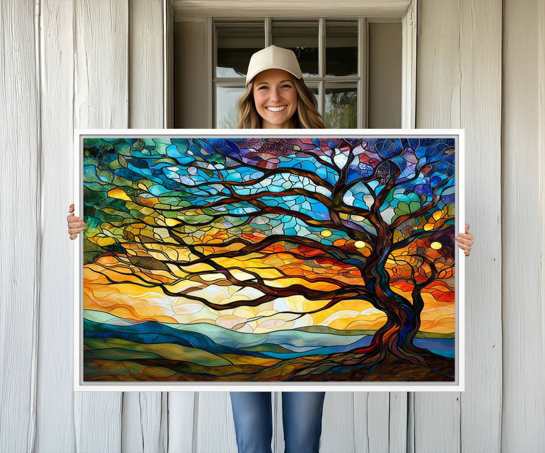 A vivid Tree of Life in stained glass style is depicted with twisted branches, a colorful sky, and hills on a ready-to-hang canvas.