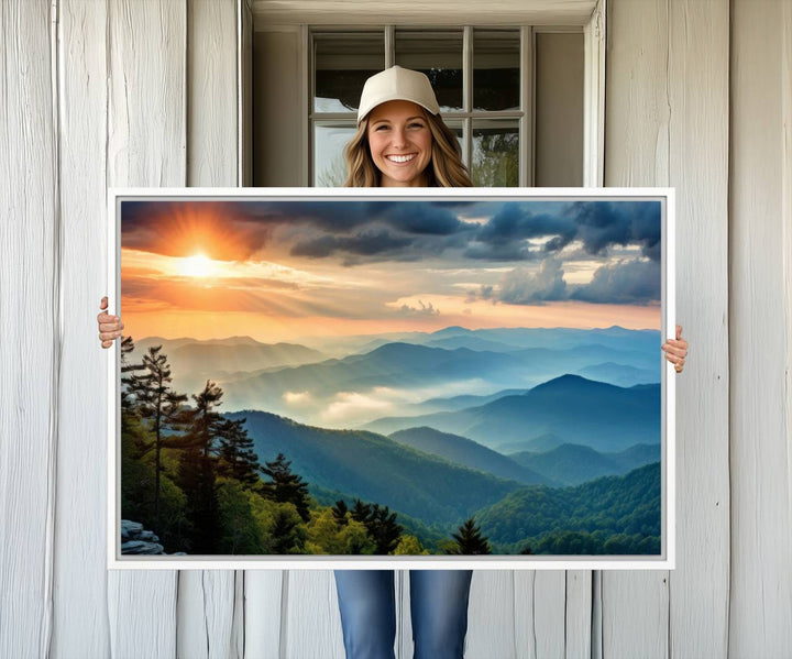 The wall art, titled Sunrise Over Mountain Range, is a canvas print that beautifully depicts layers of hills, scattered trees, and a partly cloudy sky.