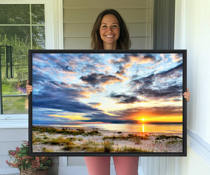 The Sunset On The Ocean canvas wall art features a beautiful beach sunset with grass and clouds.