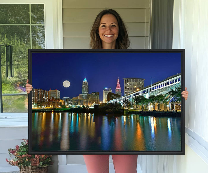 Cleveland City Lights Night Skyline Wall Art canvas showcases a moonlit cityscape reflected on water.