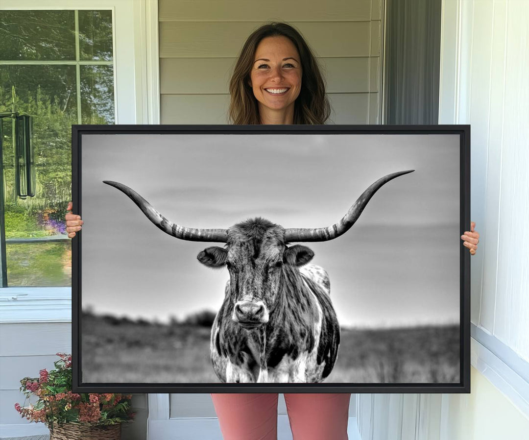 The Texas Longhorn Cow wall art, divided into three panels, is of gallery quality and displayed on a dark wall.