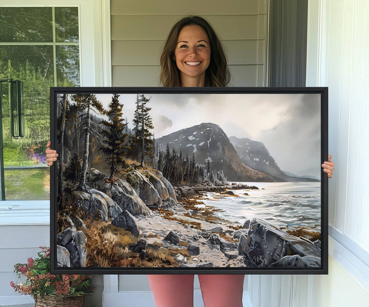 Framed wall art depicting Acadia National Parks rocky coast, trees, mountains, and sunlight over the sea; ready to hang.