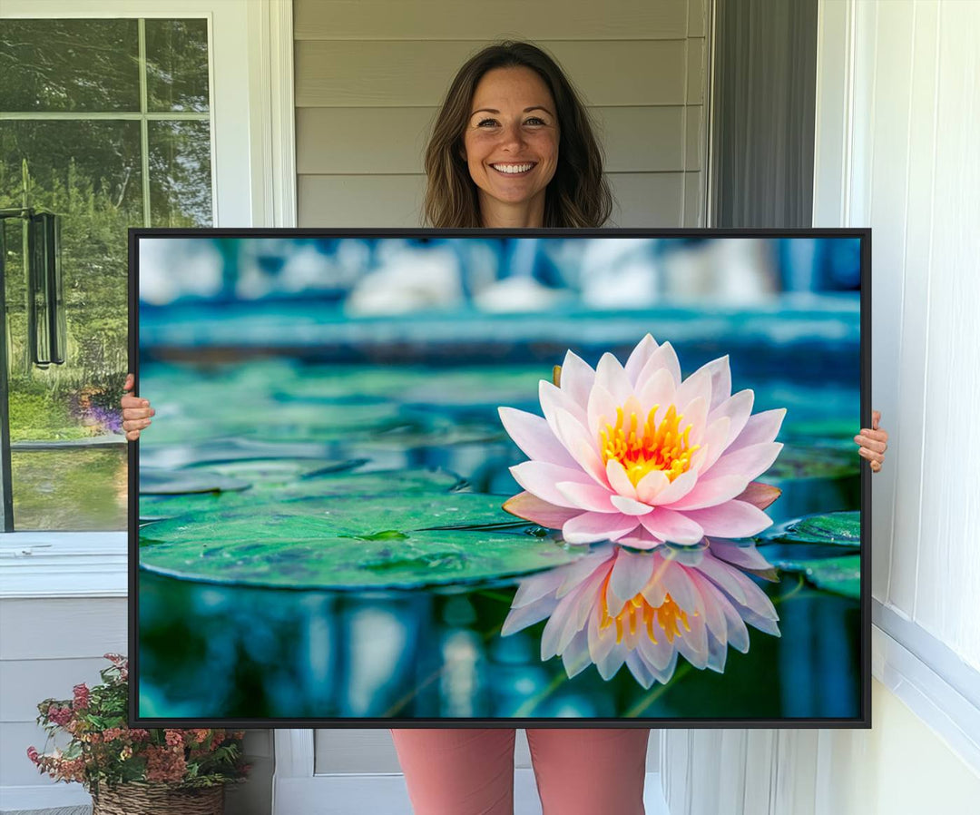 The Lotus Flower Canvas Print showcases a pink water lily with a yellow center gracefully floating on a calm pond.