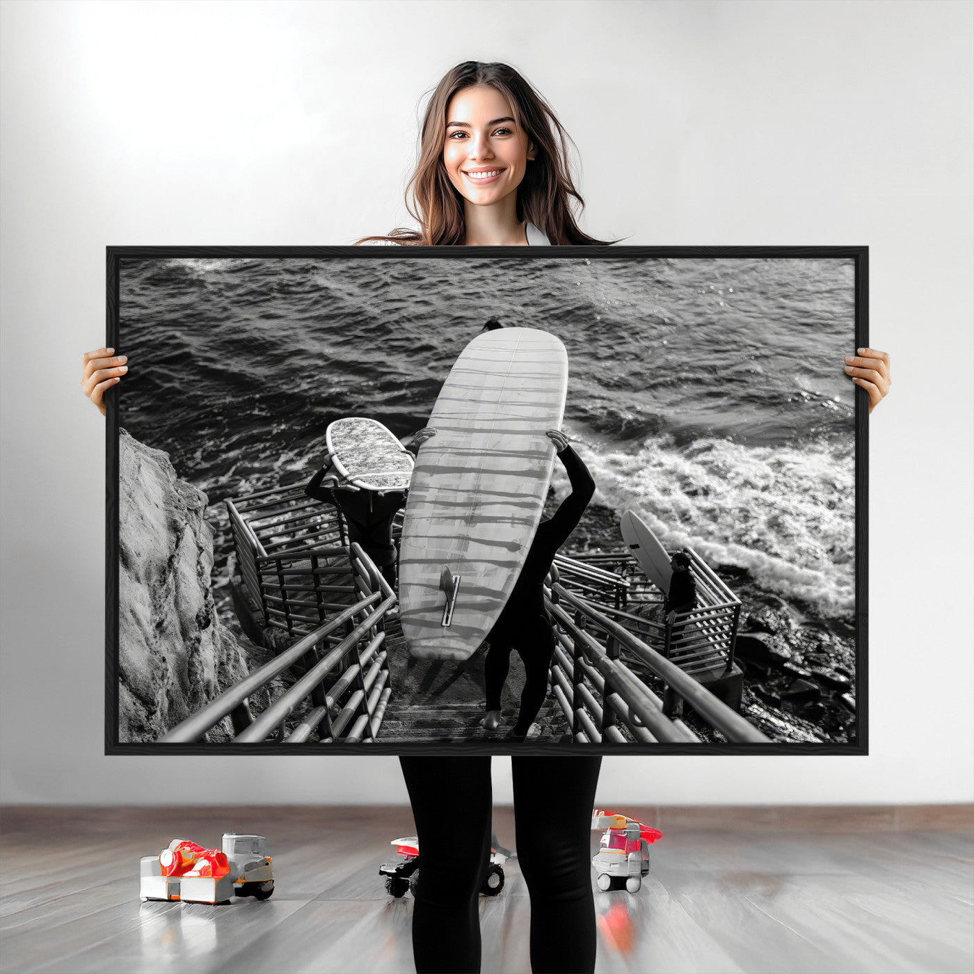Black and white photo of surfers carrying boards down a rugged cliffside stairway, capturing a bold and adventurous coastal scene.