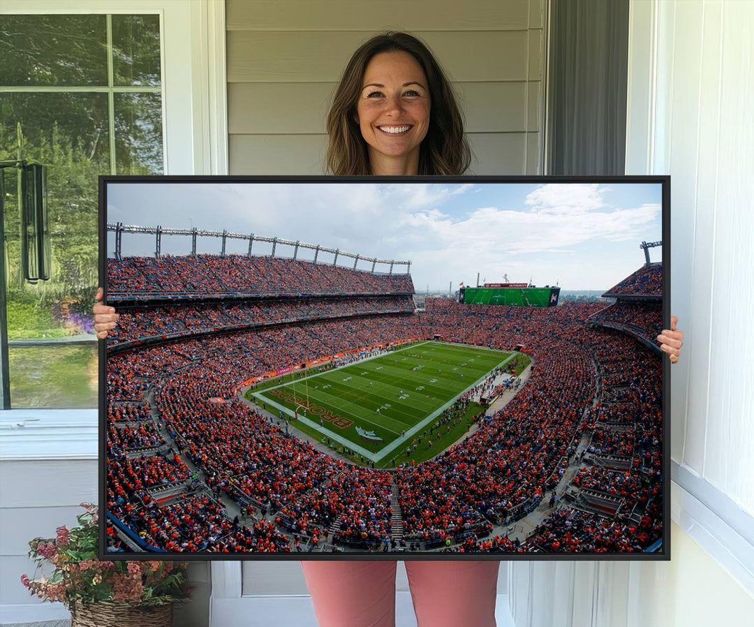 The Denver Broncos Football Print features a vibrant, fan-filled orange stadium overlooking the football field.