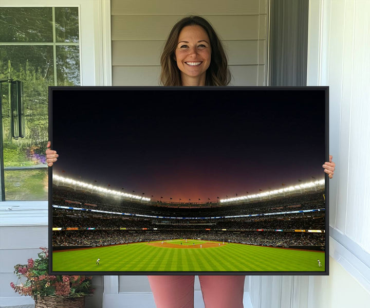 A night game at Yankee Stadium depicted on canvas beneath a sunset sky.