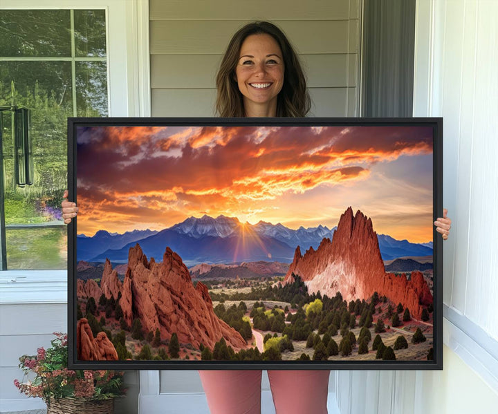 A vibrant sunset over the Rocky Mountains with red rocks.