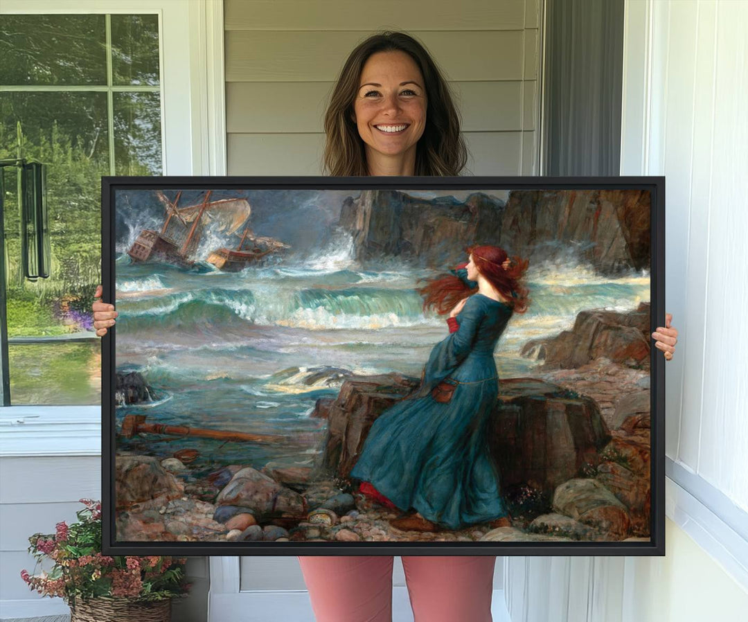 The Miranda by the Shore Wall Art Canvas Print depicts a woman in a blue dress standing by the sea, watching a shipwreck.