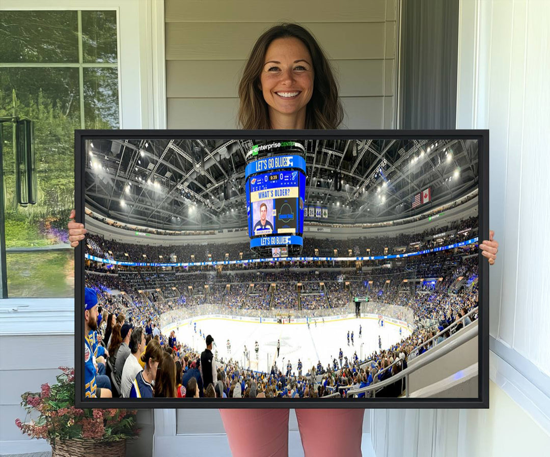 Wall art prints depicting the bustling scenes of the St. Louis Blues being cheered on by a full house at the Enterprise Center, beneath a large scoreboard.