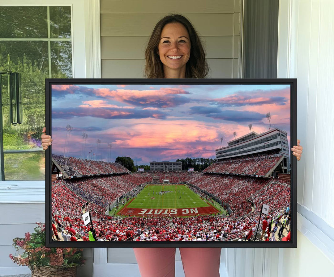 The wall art captures an NC State Wolfpack game under a vibrant sunset on triple canvas.