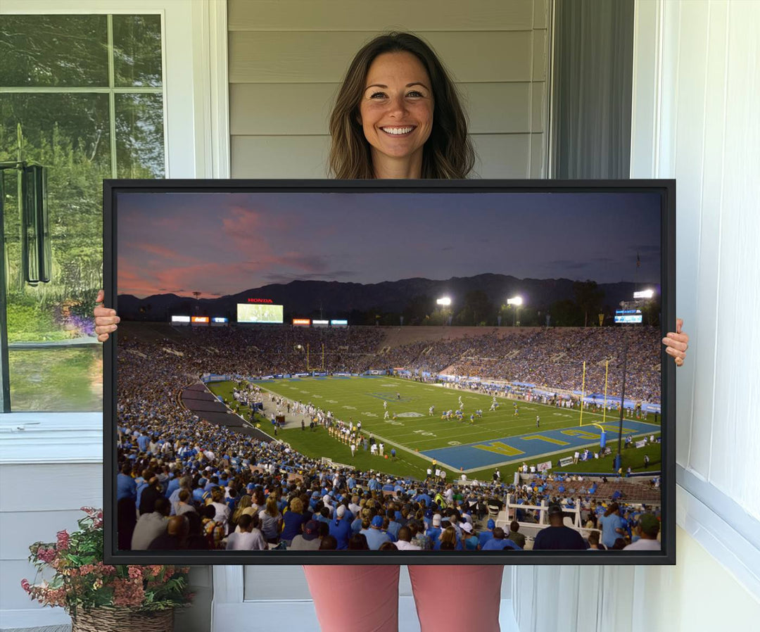 Admire the stunning wall art canvas depicting a UCLA Bruins game with a sunset over the Pasadena Rose Bowl Stadium.