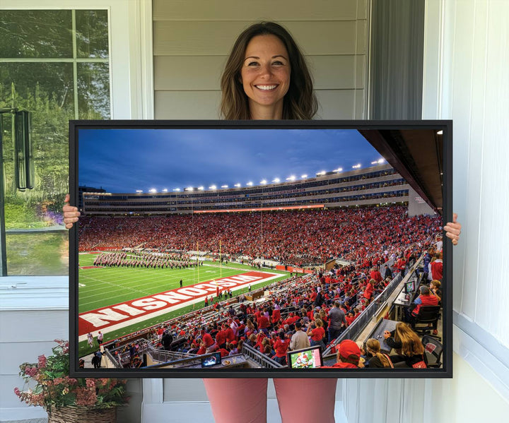 A vibrant wall art captures the essence of Madison Camp Randall Stadium, depicting a sea of fans in red and white during a Wisconsin Badgers football game under bright lights.