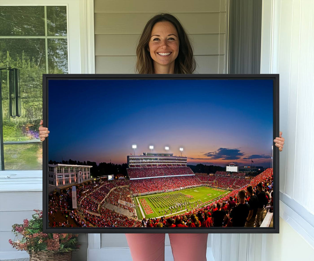 The Wolfpack Football Team Print captures a band and crowd at dusk in a premium canvas art style at Raleigh Carter-Finley Stadium.