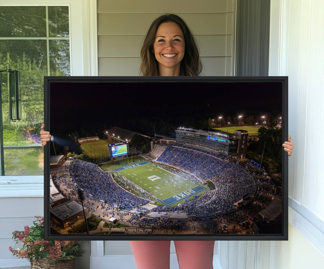 Night aerial view of packed Duke Blue Devils Wallace Wade Stadium, surrounded by trees and illuminated by lights; perfect for high-resolution prints.