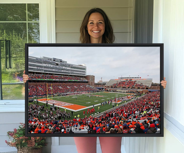 A University of Illinois Fighting Illini wall art canvas hangs on the wall, depicting a packed stadium.