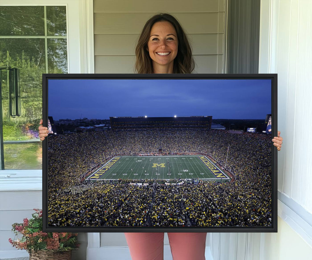 Wall art featuring an aerial shot of Michigan Stadium at dusk, showcasing the University of Michigan Wolverines M logo.