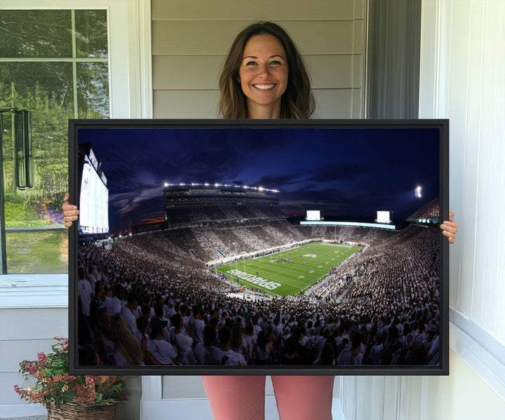 A packed football stadium at night, with bright lights and fans in white, depicted in a Michigan State Spartans Stadium wall art.