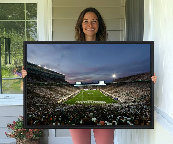 Wall art featuring a stadium at dusk with full stands—ideal for the Michigan State Spartans Football Team Canvas Print.