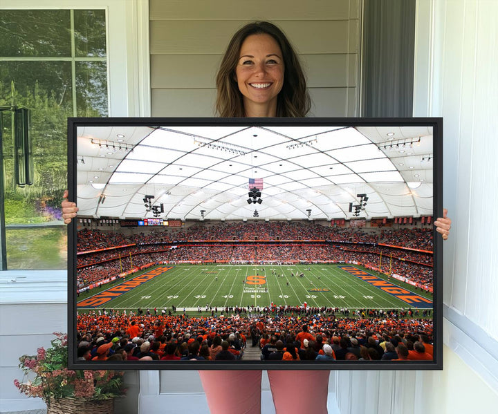 Fans fill the Syracuse JMA Wireless Dome, highlighted in orange and blue under a vaulted roof on this premium canvas print of the scene.