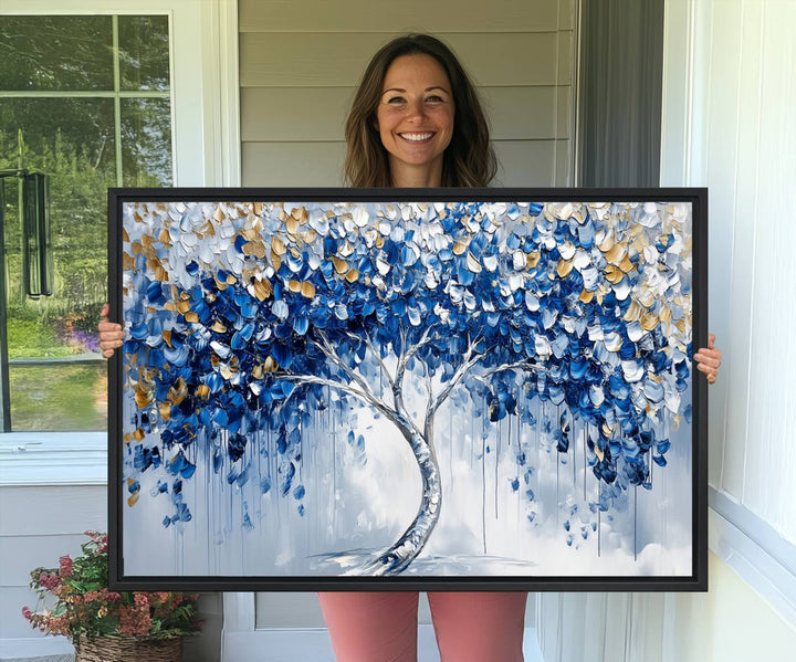 The Blue and Gold Abstract Tree Wall Art showcases a swirl trunk and features blue, silver, and gold leaves on a framed canvas print.