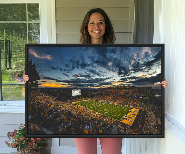 Laramies War Memorial Stadium Print captures a stunning scene of the stadium during sunset, set under a partly cloudy sky illuminated by bright lights.