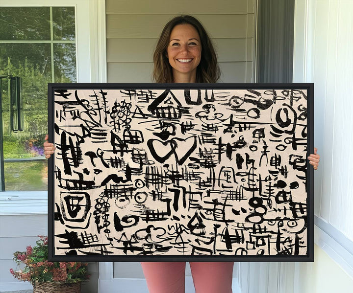 The Abstract Love and Chaos canvas is a museum-quality print featuring black symbols on a beige background, adorned with a heart and scribble design. It is framed to enhance its artistic appeal.