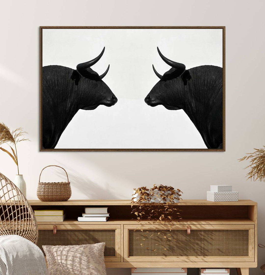 A framed canvas print featuring two black bull silhouettes, perfect for modern rustic decor.