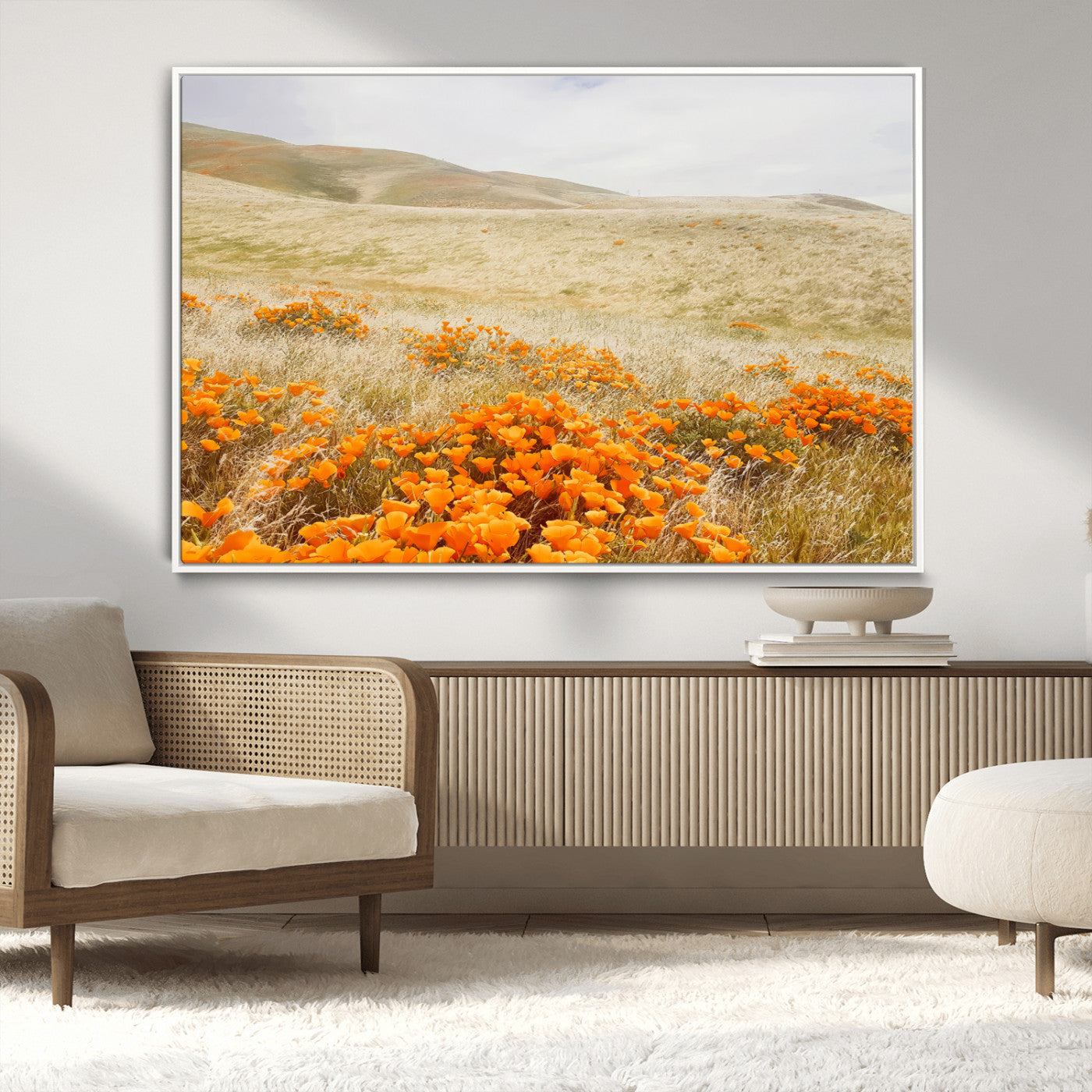 A golden field with vibrant orange poppies blooming across rolling hills under a soft, sunlit sky, creating a warm and rustic landscape.