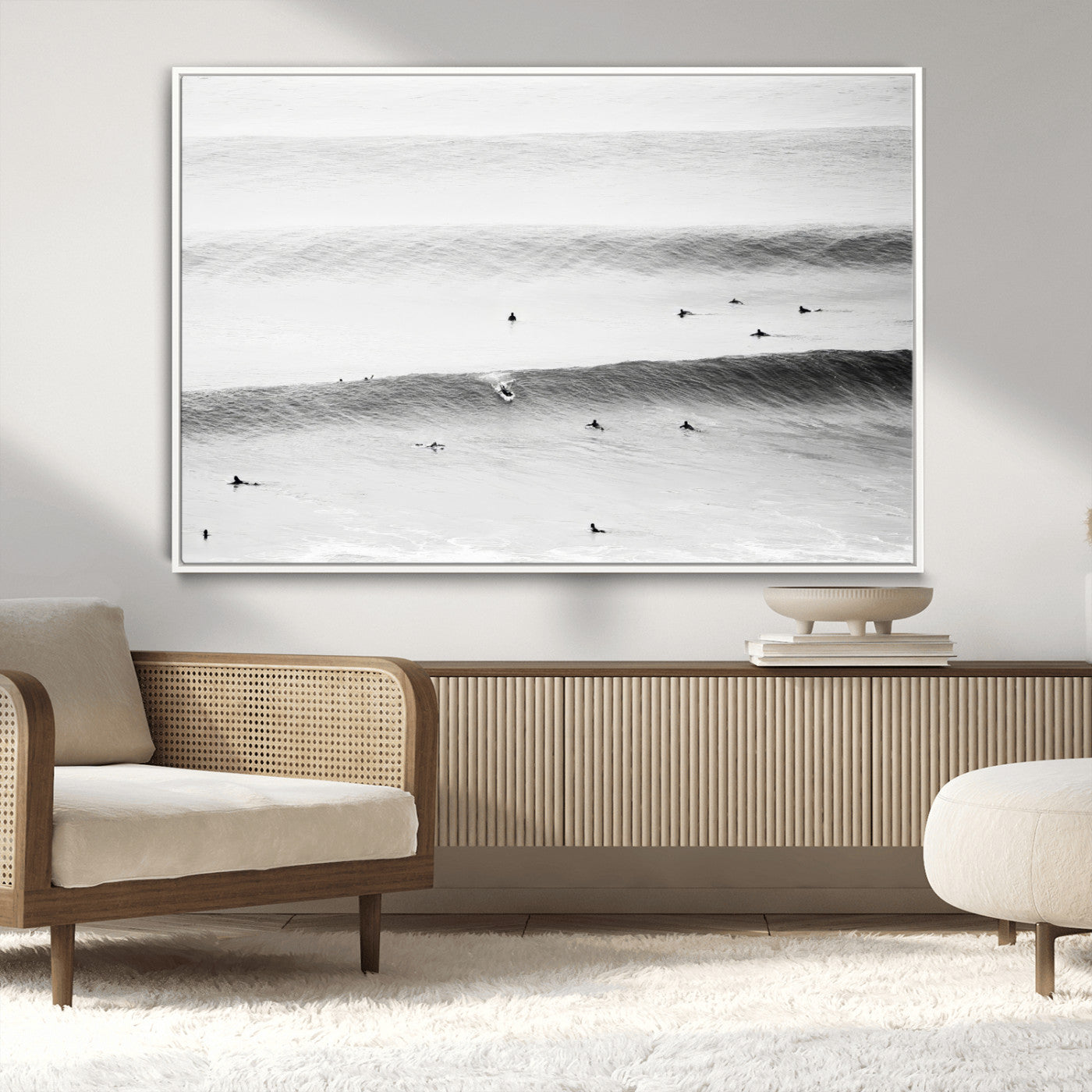 A monochrome photograph of swimmers gliding through gentle ocean waves, evoking a sense of calm and movement.