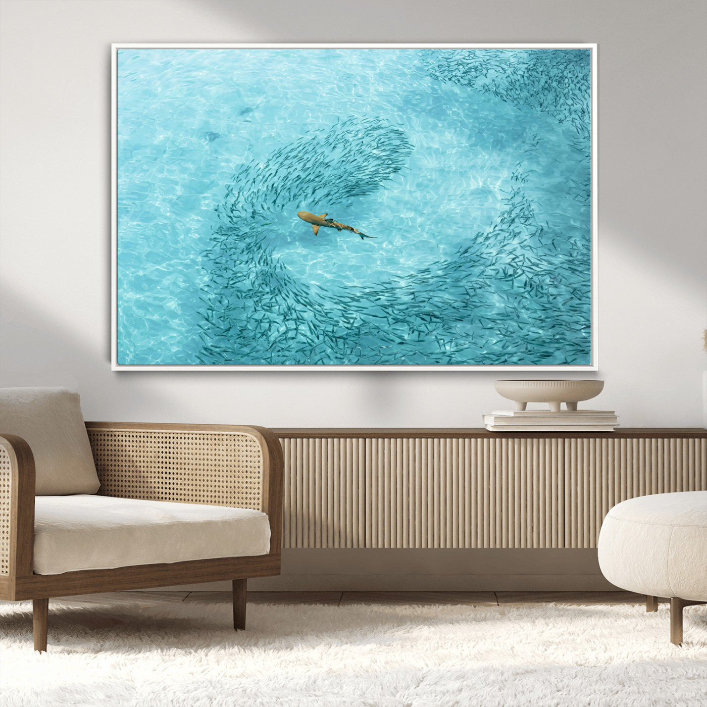 Aerial view of a shark swimming through a swirl of fish in clear turquoise waters, perfect for calm coastal or beach house decor.