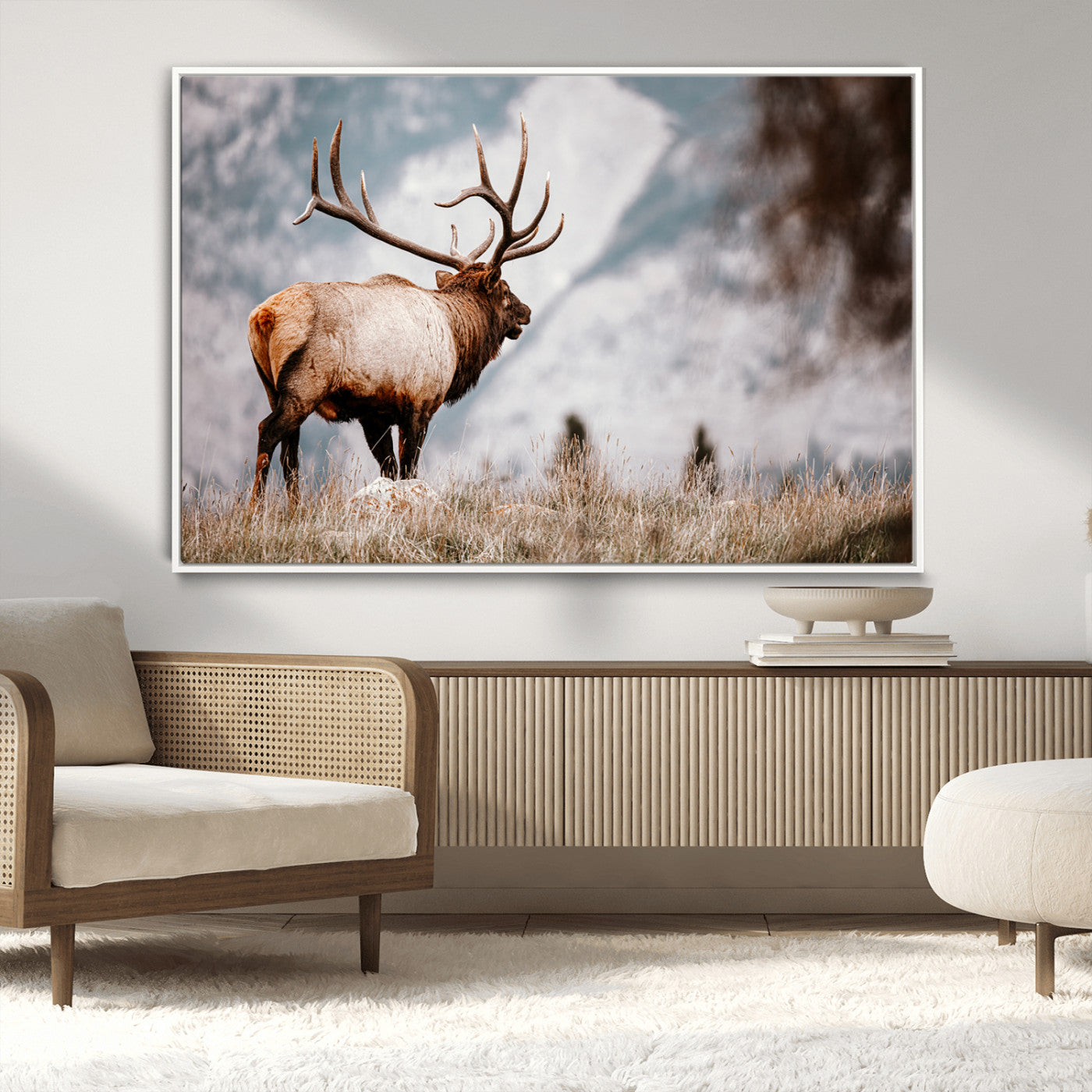 Majestic elk with large antlers standing in grass with snowy mountains in background, perfect for rustic cabin or lodge style decor.