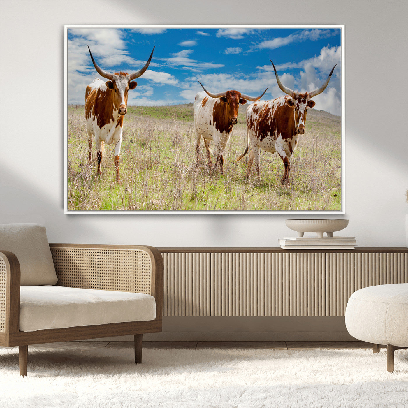 Three Texas longhorn cattle standing in dry grass under a bright blue sky, ideal for farmhouse or western rustic home decor.